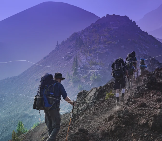 people in gear climbing up a mountain