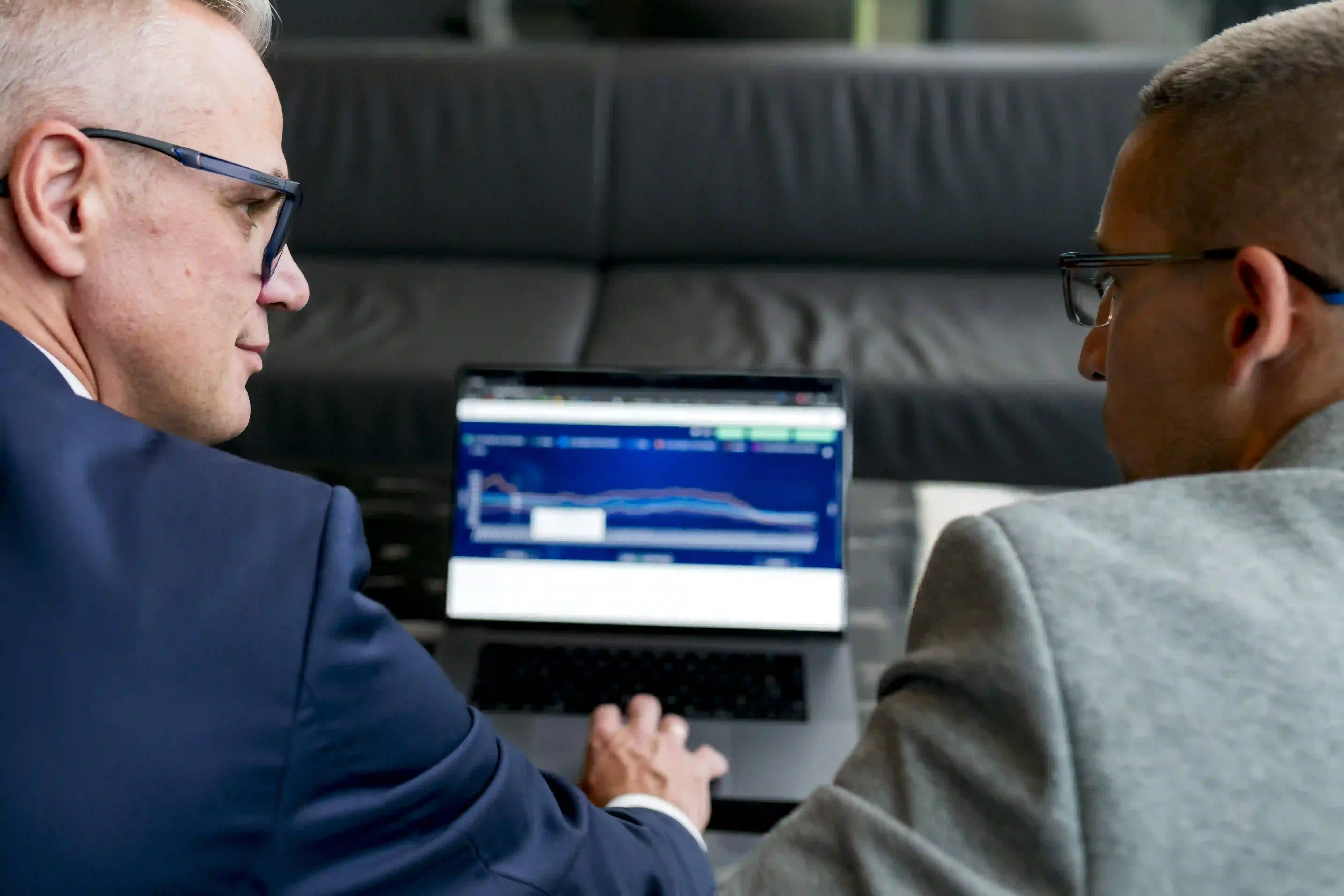 a person in a suit looking at a laptop